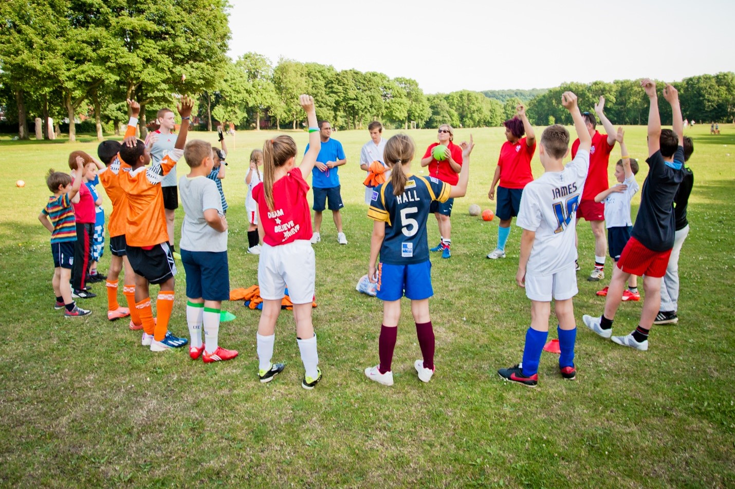 A group of children in football kits in a field.